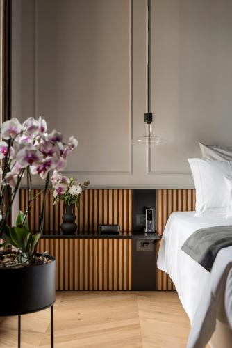 a bedroom with a bed and a table with flowers at Relais Villa Margherita in Longiano