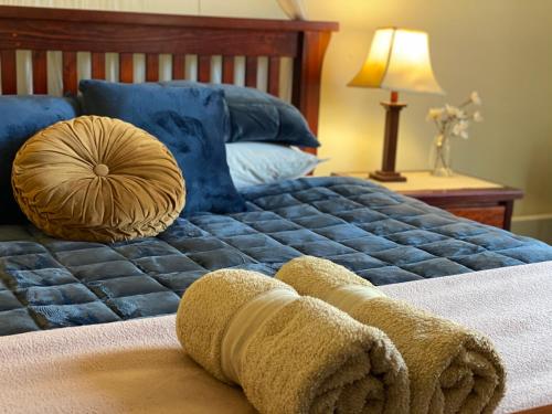a bedroom with a bed with blue sheets and blue pillows at Seacroft Estate in Apollo Bay