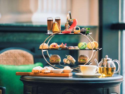 a table with a tray of pastries and coffee on it at Hotel de la Coupole - MGallery in Sa Pa