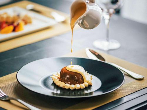 a dessert on a plate on a table with aucer at Hotel de la Coupole - MGallery in Sa Pa
