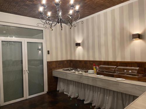 a kitchen with a counter with a sink and a chandelier at Hotel Restaurant Mirena in Marl