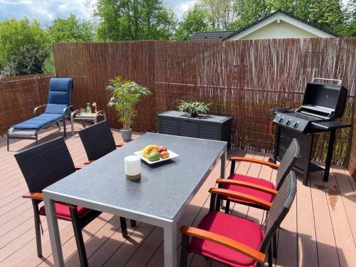 a patio with a table and chairs and a grill at Ferienwohnung Kaiserblick in Stephanskirchen