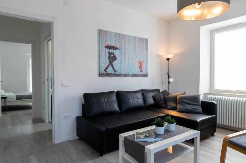 a living room with a black couch and a table at Numero 53 Tenna OSPITAR in Tenna 