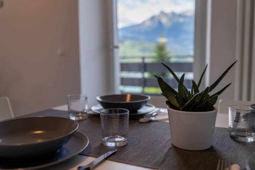 a table with two bowls and a potted plant on it at Numero 53 Tenna OSPITAR in Tenna 