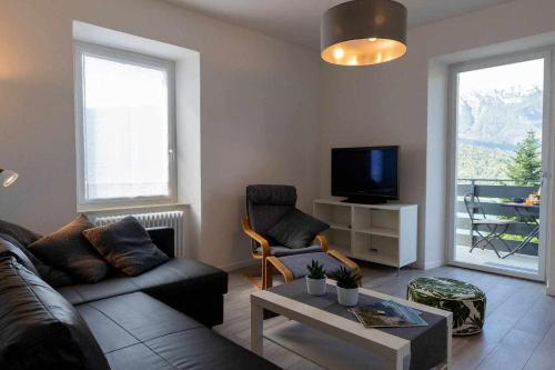 a living room with a couch and a tv and a table at Numero 53 Tenna OSPITAR in Tenna 