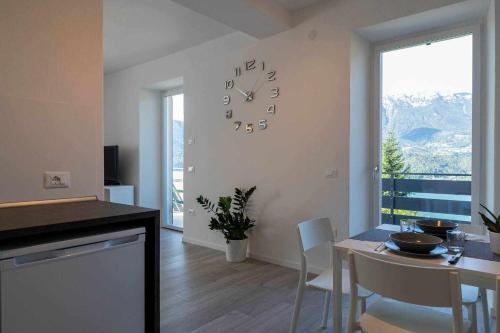 Numero 53 Tenna OSPITAR في تينّا: مطبخ وغرفة طعام مع ساعة على الحائط