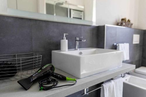 a bathroom with a white sink and a vacuum at Numero 53 Tenna OSPITAR in Tenna 