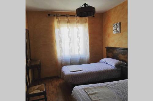 - une chambre avec 2 lits et une fenêtre dans l'établissement Casa Rural La Vizana, à Alija de los Melones
