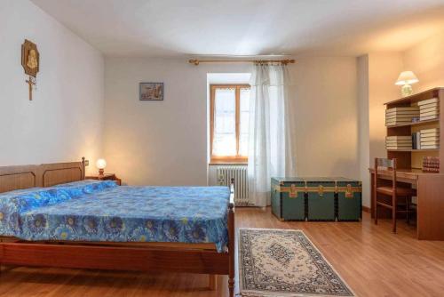 1 dormitorio con cama, escritorio y ventana en Appartamento Da Vittoria Valda Val di Cembra, en Valda