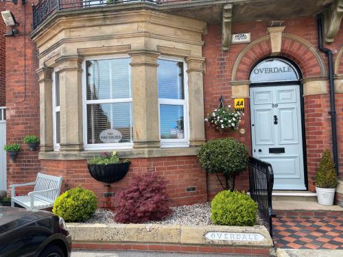 a red brick house with a white door and windows at Overdale Guesthouse and Free Parking in Whitby
