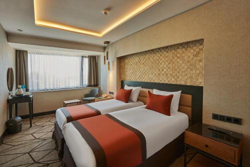 イスタンブールにあるGrand Hotel Gulsoy Old Cityのベッド2台とデスクが備わるホテルルームです。