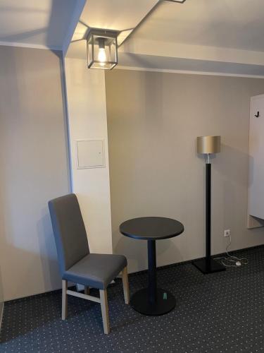 a table and a chair and a lamp in a room at Hotel Restaurant Mirena in Marl