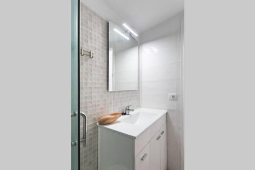 a white bathroom with a sink and a mirror at Horizonte Atlántico: Un Rincón en el Paraíso in Azano