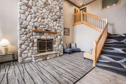 uma sala de estar com uma lareira de pedra e uma escadaria em Quality Inn & Suites em Lodi