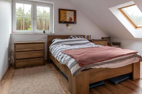 een slaapkamer met een houten bed op zolder bij Przystań Kopalino in Kopalino
