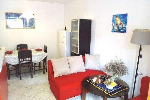 sala de estar con sofá rojo y mesa en Una's House of Joy, en Isla Krapanj