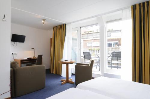 ein Hotelzimmer mit einem Bett und einem Balkon in der Unterkunft Hotel de Burg in Domburg
