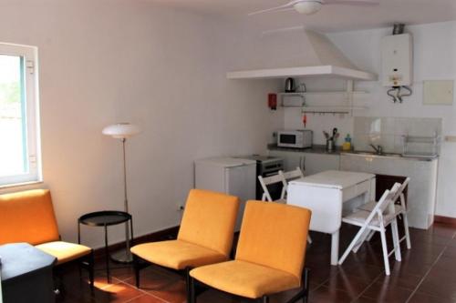 cocina con sillas de color naranja y mesa en una habitación en Casa do Rio en Covelinhas