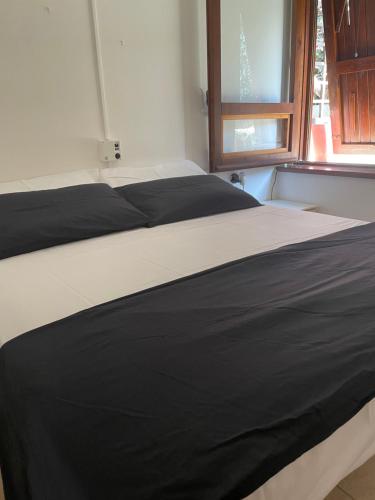 czarno-białe łóżko w pokoju z oknem w obiekcie SeaView Apartments 79 w mieście Palau