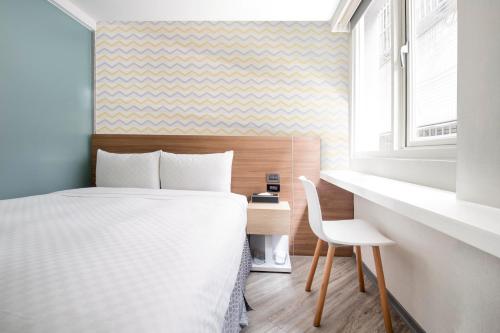 a bedroom with a bed and a desk and a window at Cityinn Hotel Taipei Station Branch I in Taipei