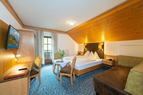 a hotel room with a bed and a couch at Naturhotel Hüttenwirt im Grossarltal in Hüttschlag