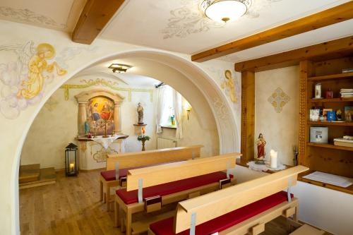 a church with a altar and benches in it at Naturhotel Hüttenwirt im Grossarltal in Hüttschlag