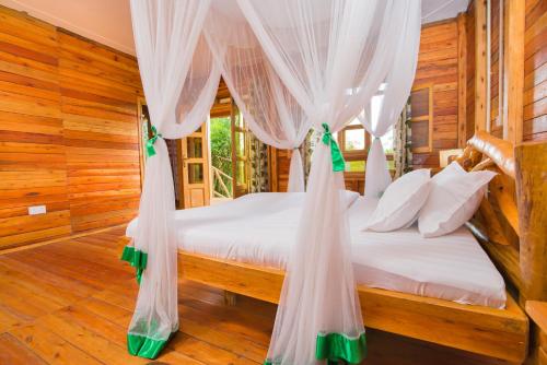 a bedroom with a bed with mosquito netting at Engiri Game Lodge and Campsite in Katunguru