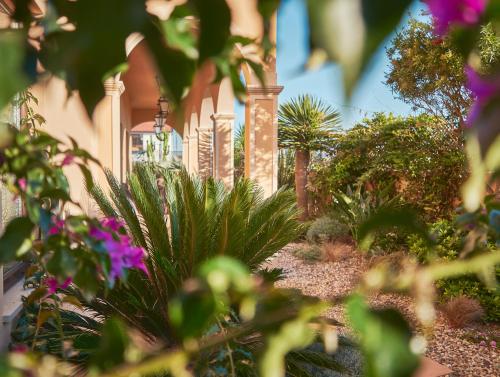 a garden with plants and flowers in front of a house at Silver Coast Beach Residence in Baleal