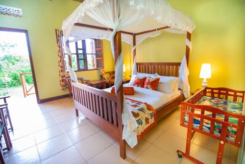 a bedroom with a canopy bed and a table at Engiri Game Lodge and Campsite in Katunguru