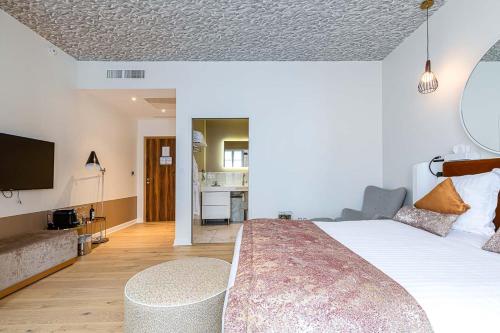 a bedroom with a large bed and a television at Hotel Le Saint Gelais in Angoulême