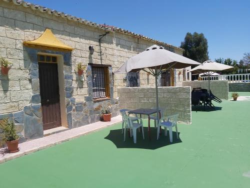 a patio with a table and chairs and an umbrella at Los Duendes in El Puerto de Santa María
