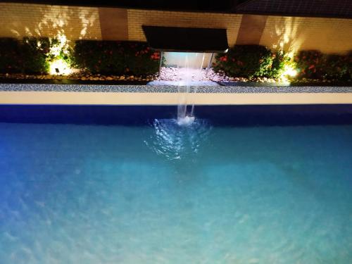 a swimming pool with a fountain in a building at Imperial Flat Tambaú - João Pessoa in João Pessoa
