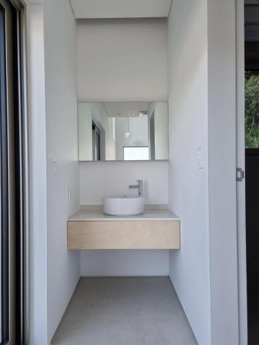 a bathroom with a sink and a mirror at Laon on 37 in Tongyeong