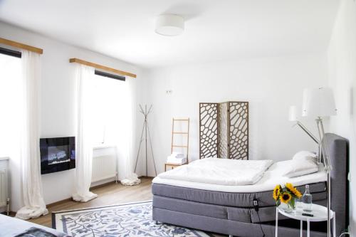 a white bedroom with a bed and a tv at Glück am See - Apartment mit Seezugang in Hallstatt