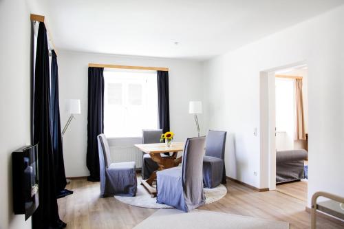ein Wohnzimmer mit einem Tisch und Stühlen in der Unterkunft Glück am See - Apartment mit Seezugang in Hallstatt
