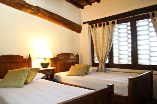 1 dormitorio con 2 camas y ventana en Casina Di Cornia en Castellina in Chianti