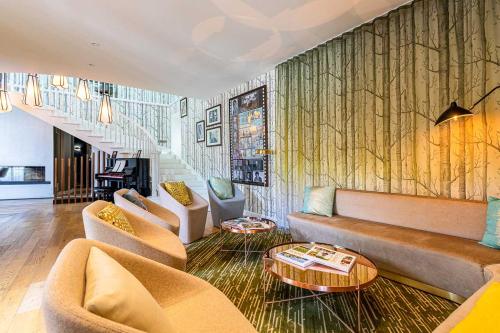 a living room with a couch and chairs and a table at Hotel Le Saint Gelais in Angoulême
