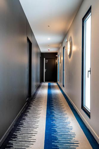 a hallway with a blue stripe on the floor at Hotel Le Saint Gelais in Angoulême