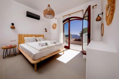 a bedroom with a bed and a large window at Kale Suites, heated pool in winter, adults only in Kaş