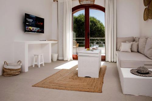 a living room with a couch and a table at Kale Suites, heated pool in winter, adults only in Kaş