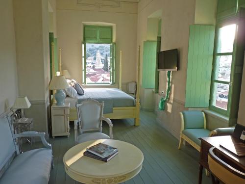 a bedroom with a bed and a table and chairs at The Old Markets in Symi