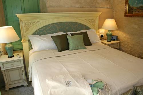a bedroom with a large white bed with two lamps at The Old Markets in Symi