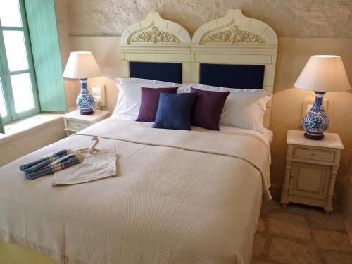 a bedroom with a large white bed with two lamps at The Old Markets in Symi