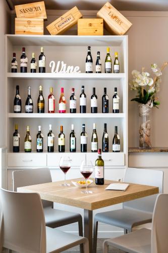 a room with a table and wine bottles on shelves at Pace 1954 Hotel in Arco