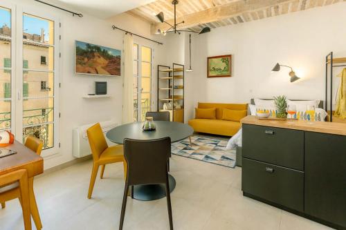 a living room with a table and a yellow couch at Provence Au Coeur Appart Hotels in Forcalquier