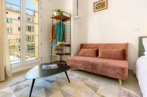 a living room with a couch and a table at Provence Au Coeur Appart Hotels in Forcalquier