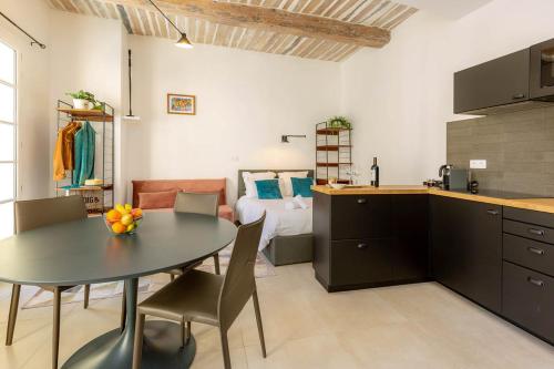 a kitchen and dining room with a table and chairs at Provence Au Coeur Appart Hotels in Forcalquier
