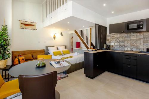 a hotel room with a bed and a table and chairs at Provence Au Coeur Appart Hotels in Forcalquier
