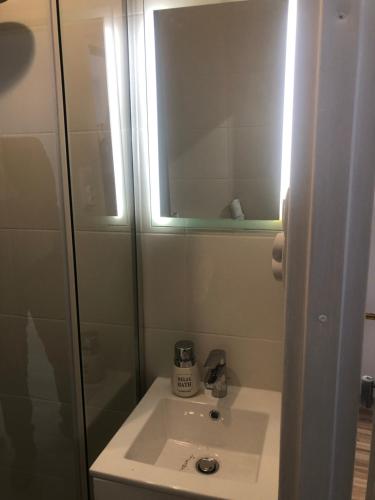 een badkamer met een wastafel en een spiegel bij Apartament Wygodny S5 in Kalisz