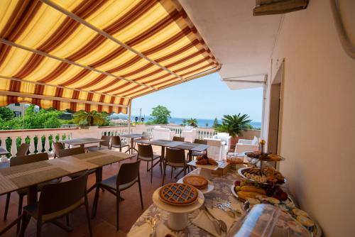 Un restaurante con mesas y sillas y un balcón. en B&B Esterita, en Parghelia